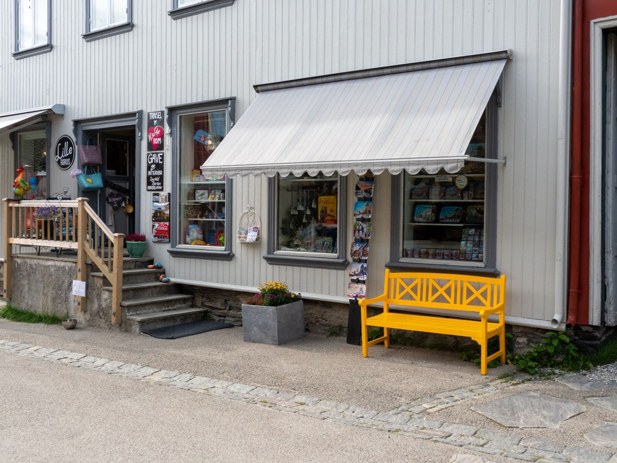 Bilde av butikk og gul benk.